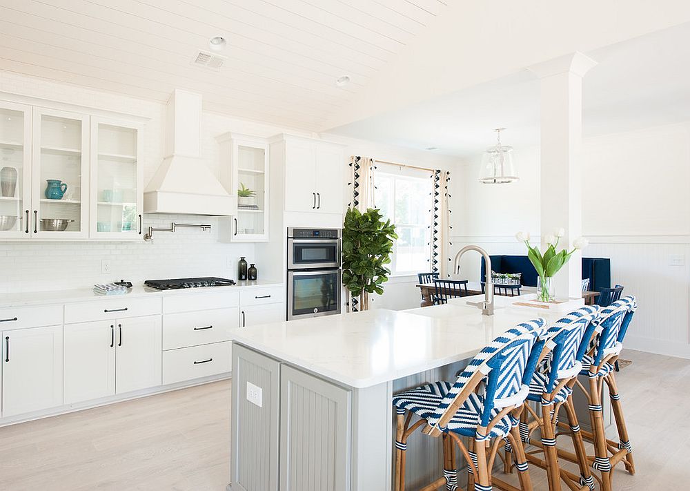 Bar chairs bring pattern to the all white kitchen with relaxing beach style
