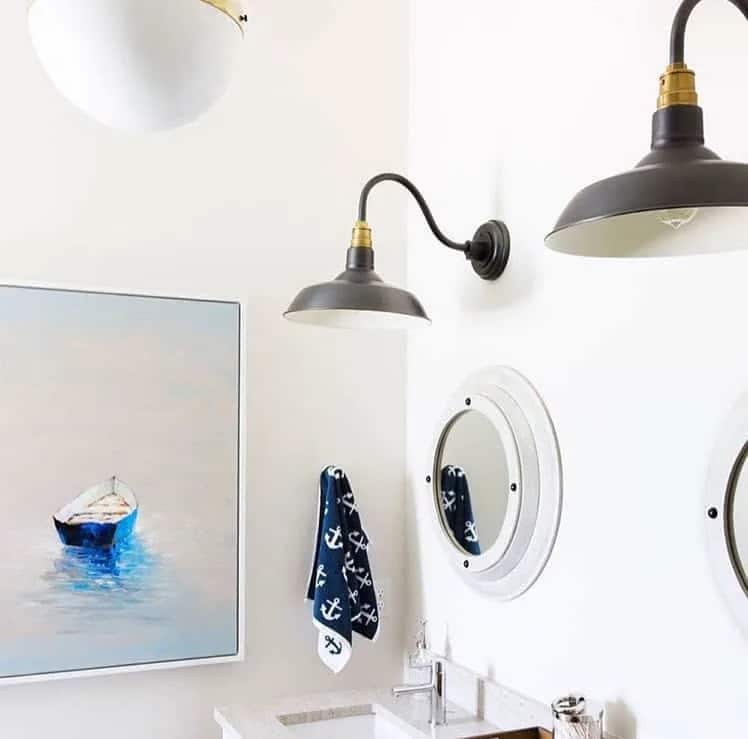 white bathroom with anchor towel and boat painting