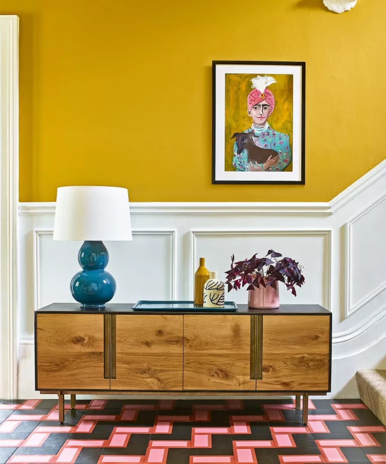  vibrant yellow in this midcentury entryway is paired up with crisp white woodwork