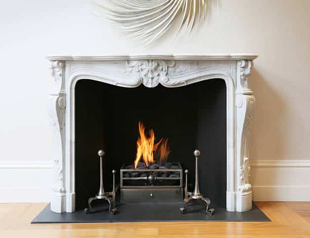 Stunning marble fireplace with roaring flames.