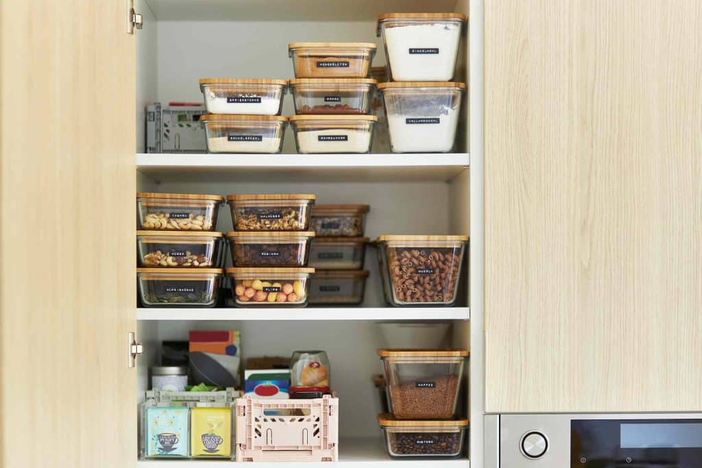 Utilize Stackable Bins to Organize Baking Sheets and Cutting Boards