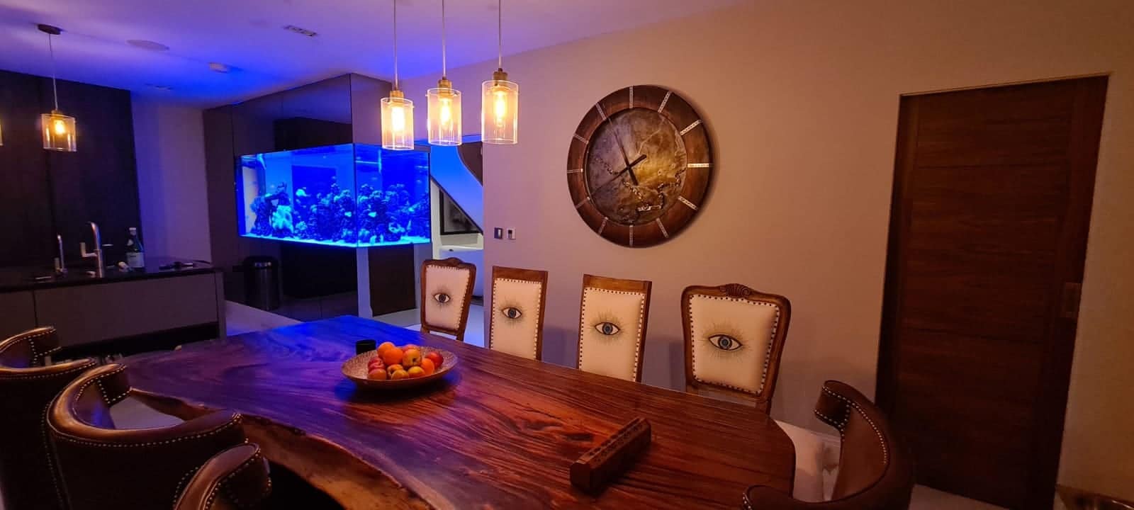 A dining table with chairs and a bowl of fruit on it AI-generated content may be incorrect.