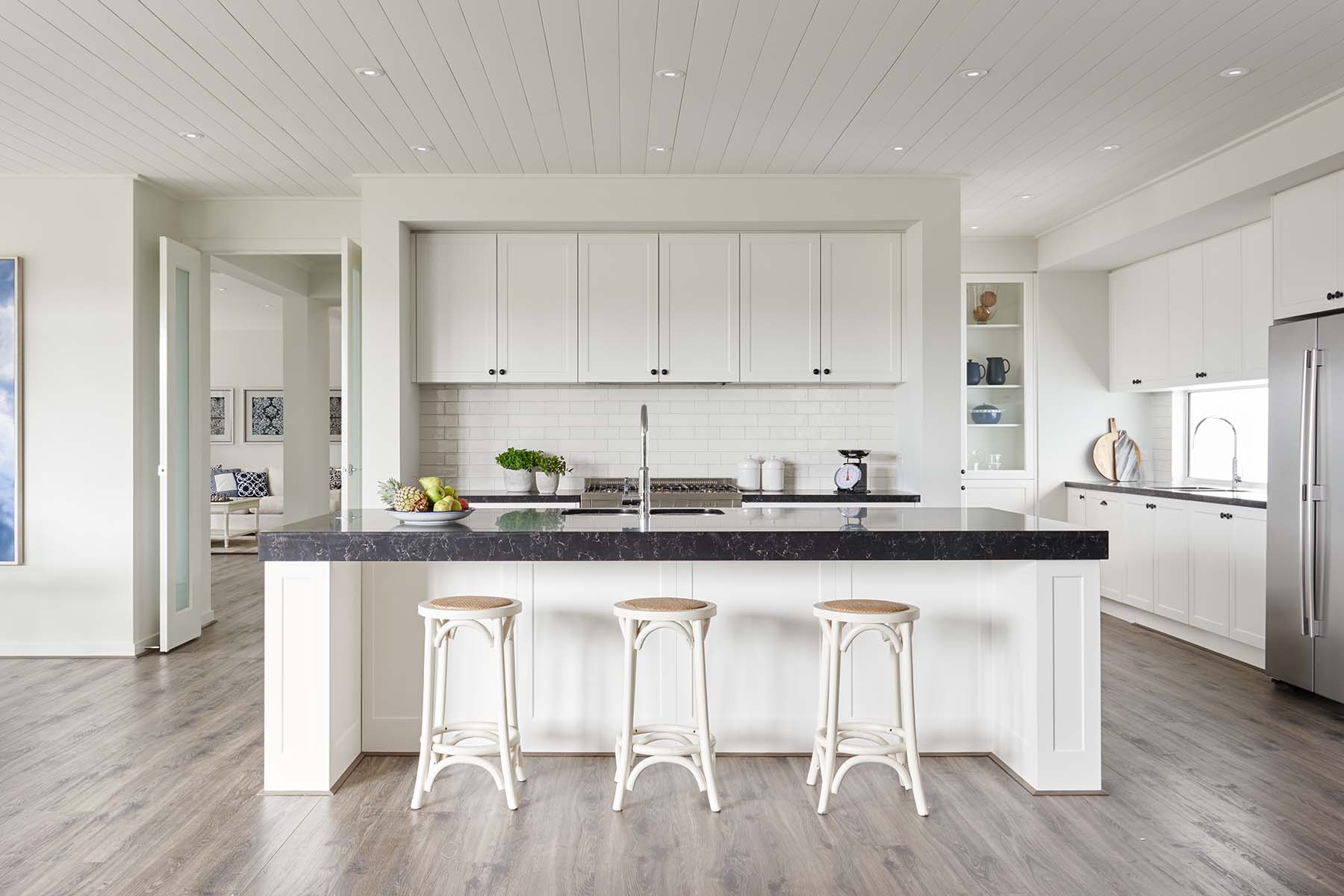 A kitchen with white cabinets and black counter tops

AI-generated content may be incorrect.