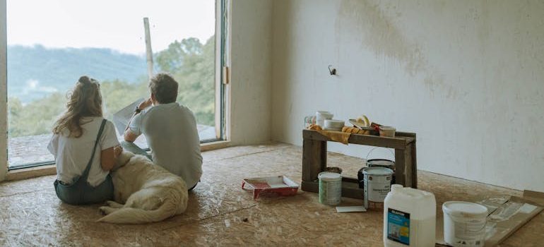 a couple with a dog, taking a break during renovation