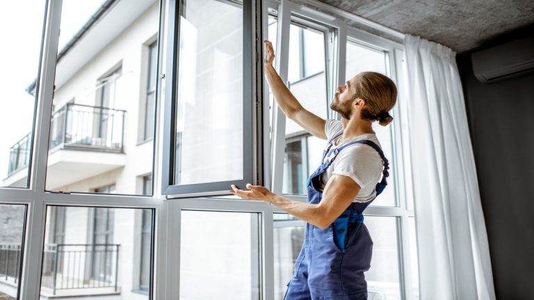 Workman adjusting window frames at home