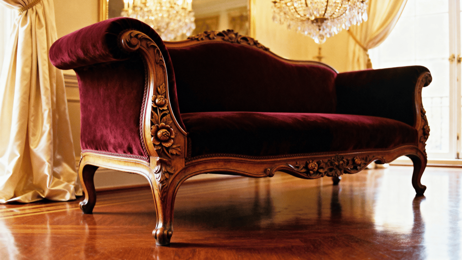 Cabriole sofa with carved wood frame and curved legs in a formal sitting room.