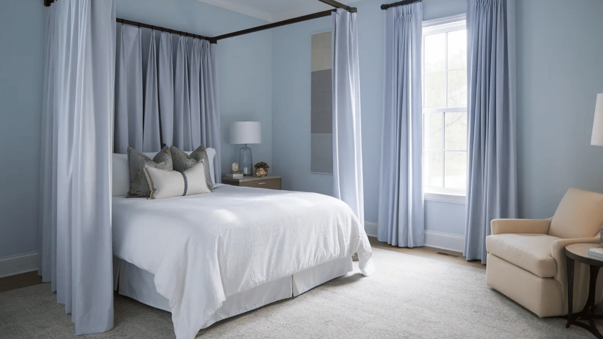 bedroom with soft blue blackout curtains framing a large window, offering privacy and light control