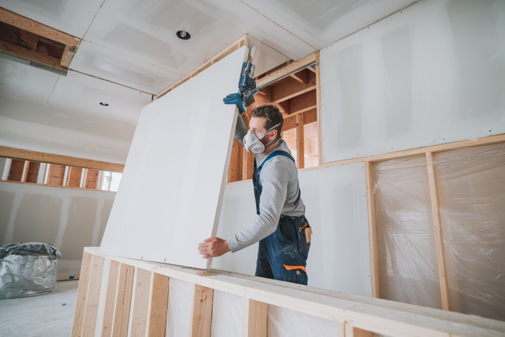 construction worker working on a wall with drywall