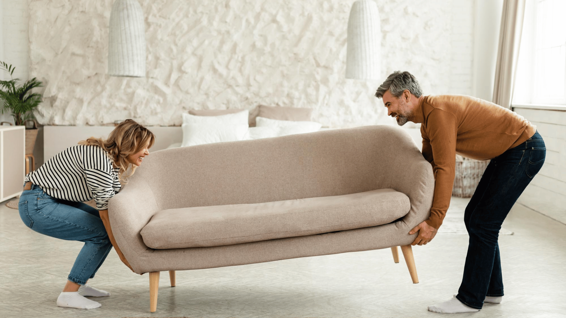 couple sorting through old furniture deciding between donation, selling, or disposal options.
