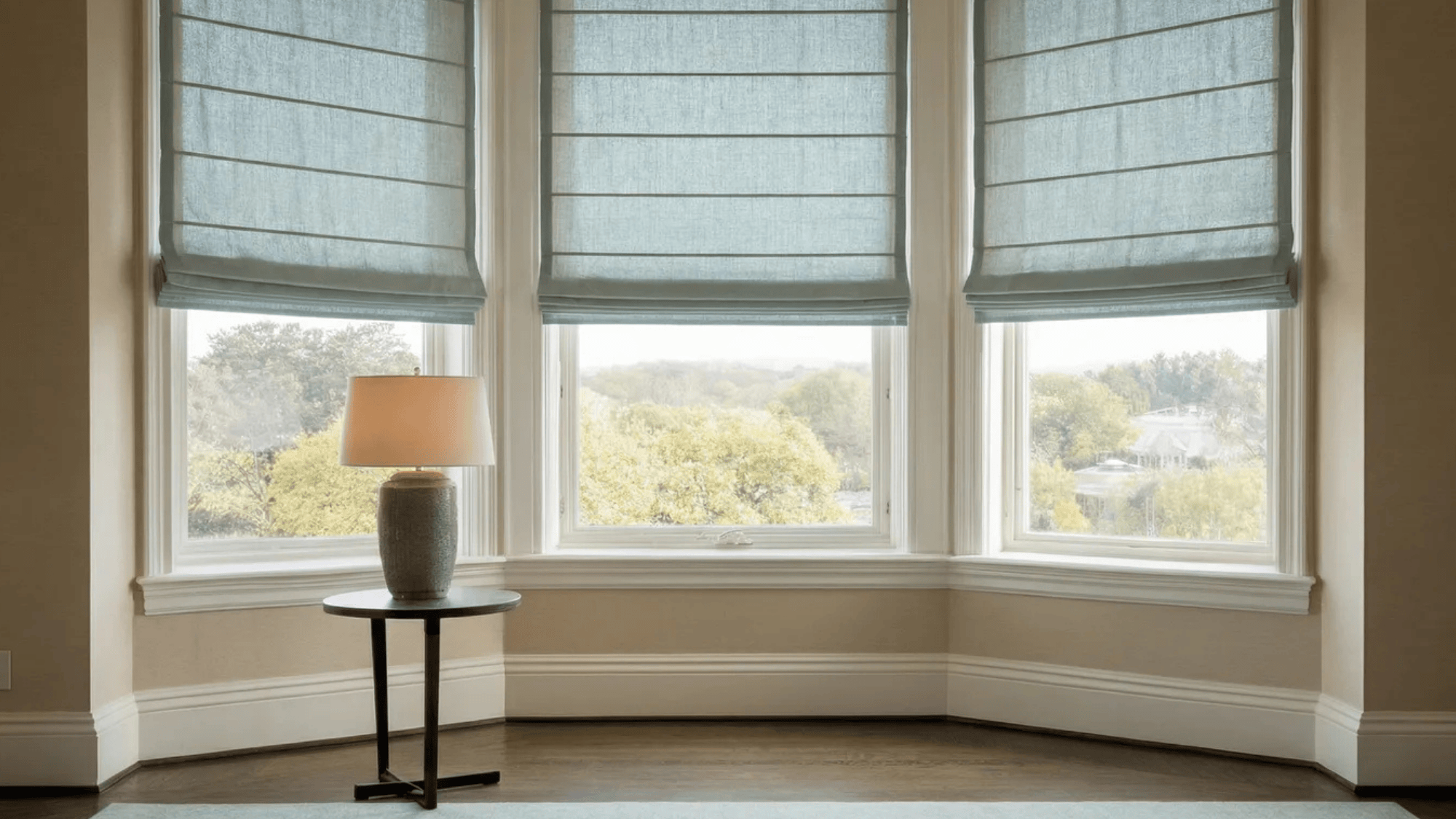 flat Roman shades in a living room window, offering a sleek, smooth appearance with soft fabric folds