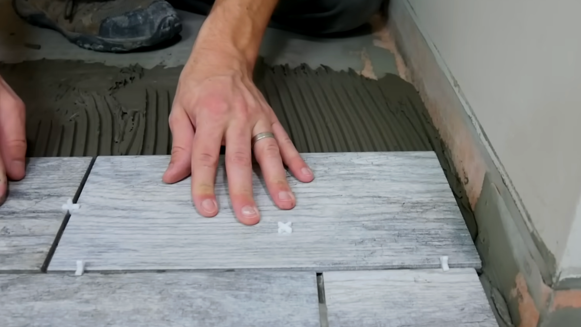 man tilling and making final cuts after tile installation