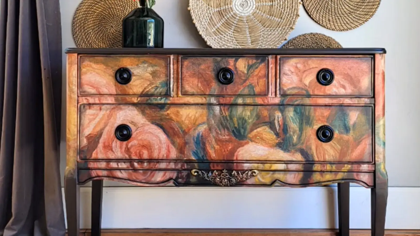 Finished dresser with blended floral decoupage drawers, dark stained top, and decorative wall baskets above.