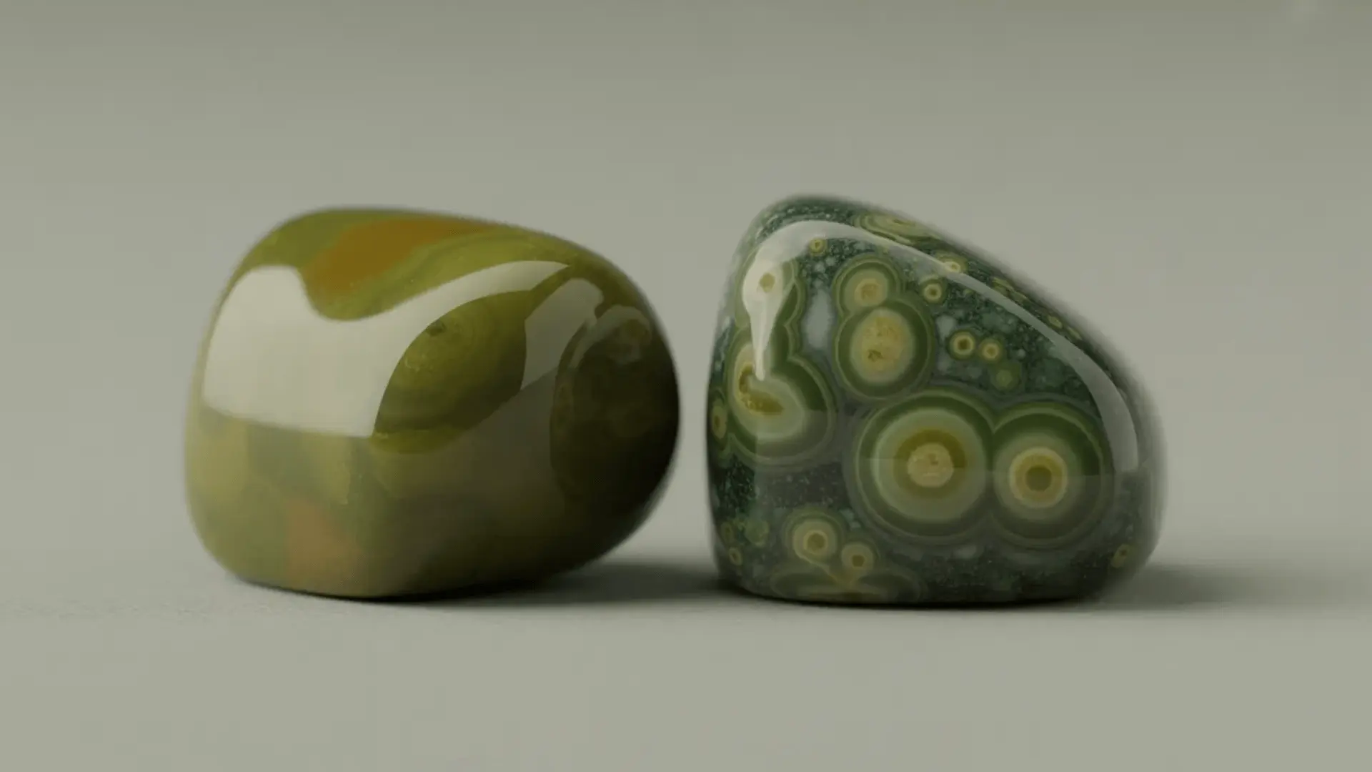Green jasper stone and Kambaba jasper with circular patterns placed side by side on a neutral background