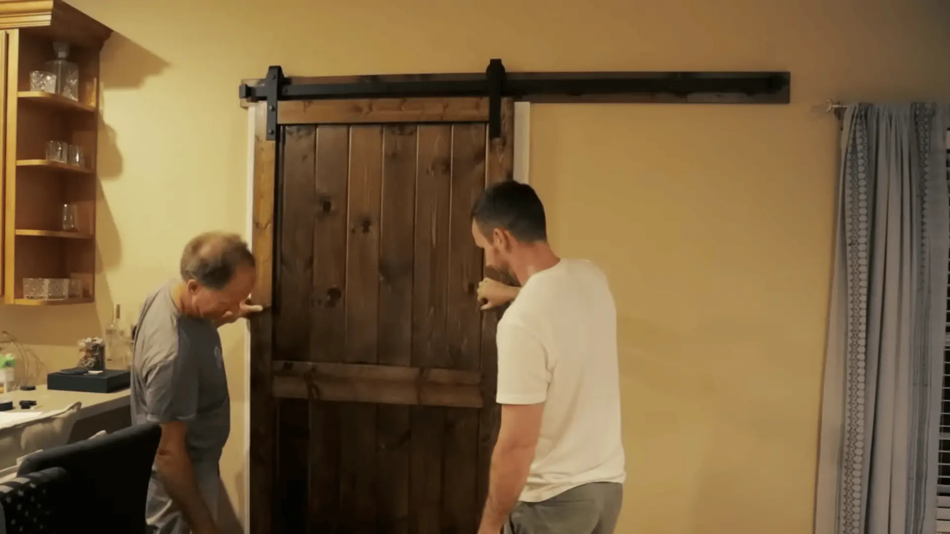 Installing the header board and sliding rail above the doorway to hang the barn door.