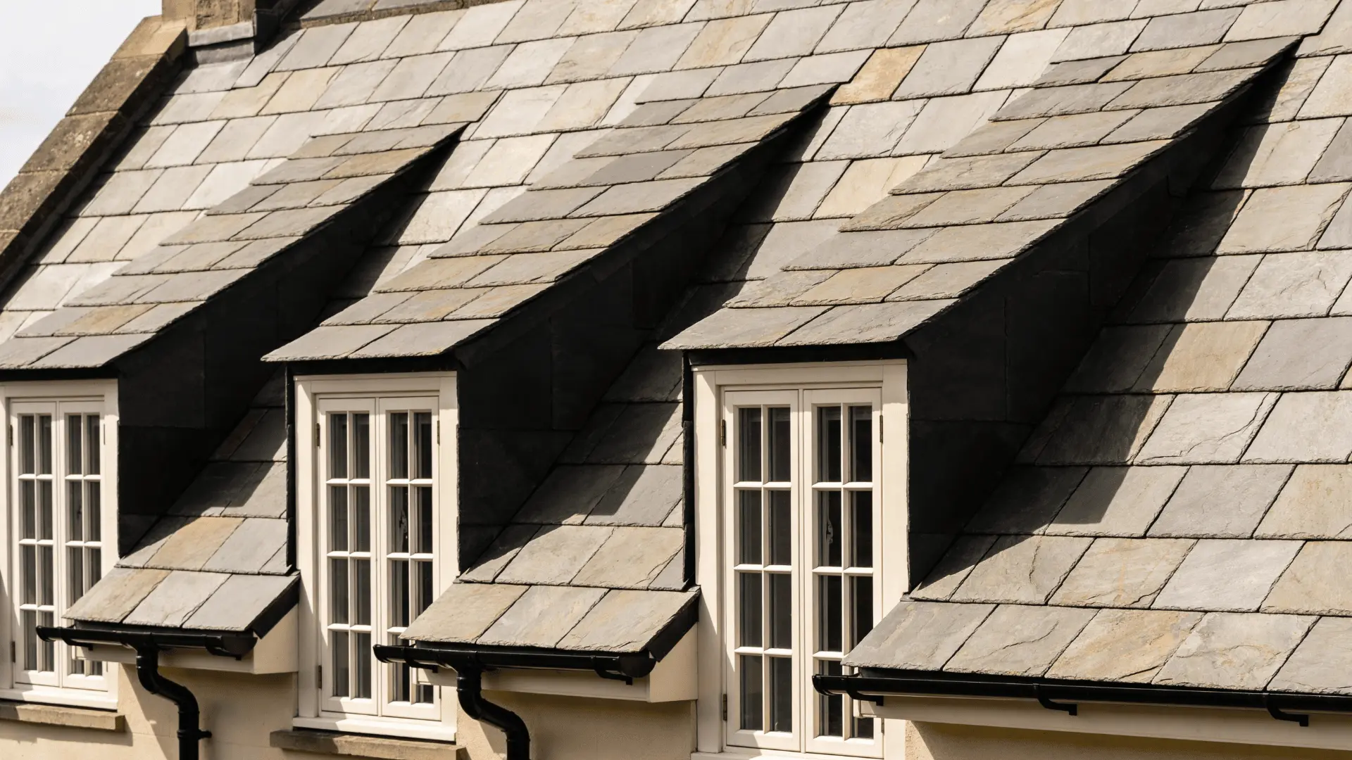 Slate roof tiles installed in rows showing flat rectangular stone pieces and surface texture