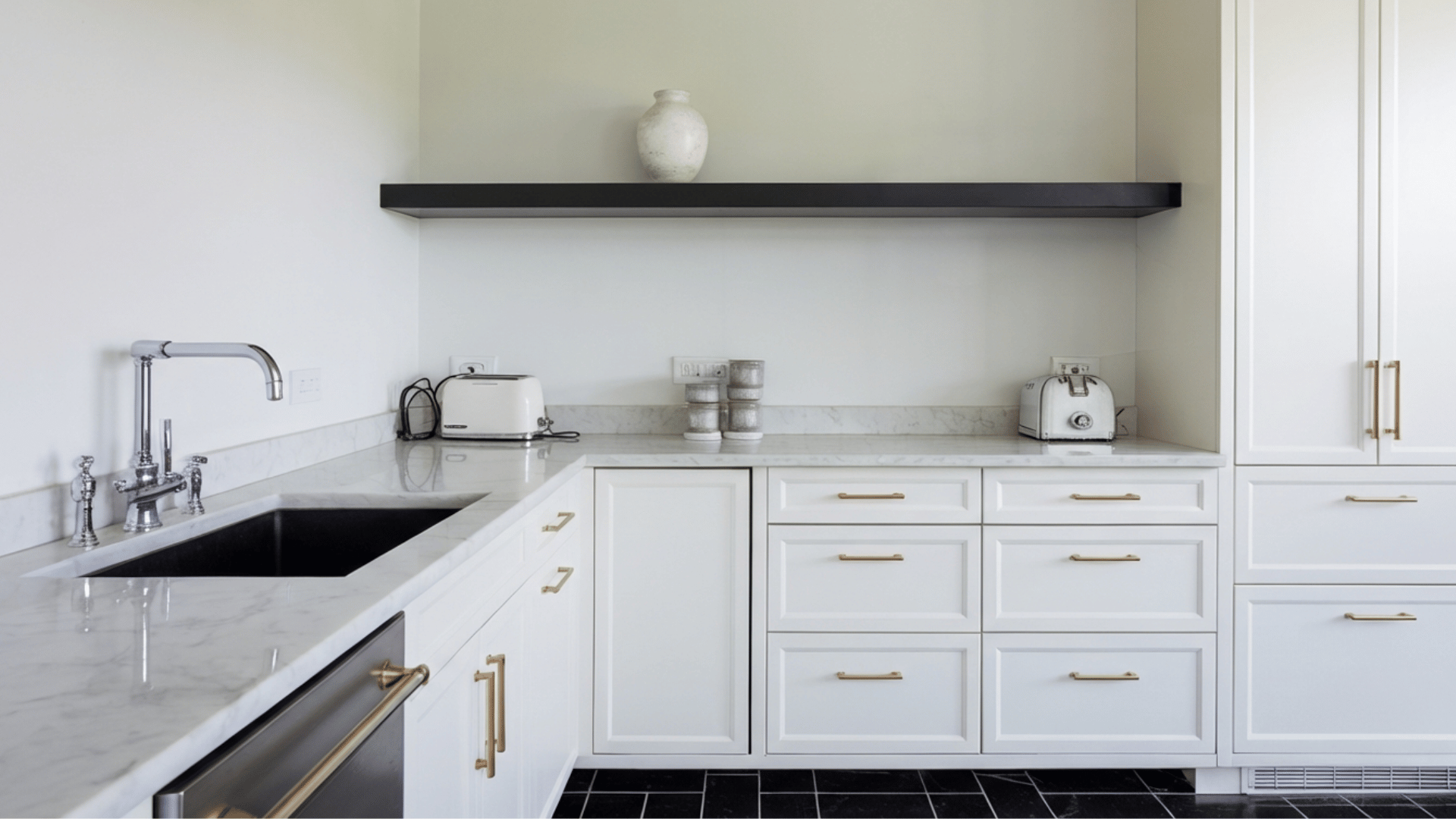 a modern kitchen with white cabinets, marble countertops, and brass hardware, featuring a sleek design.