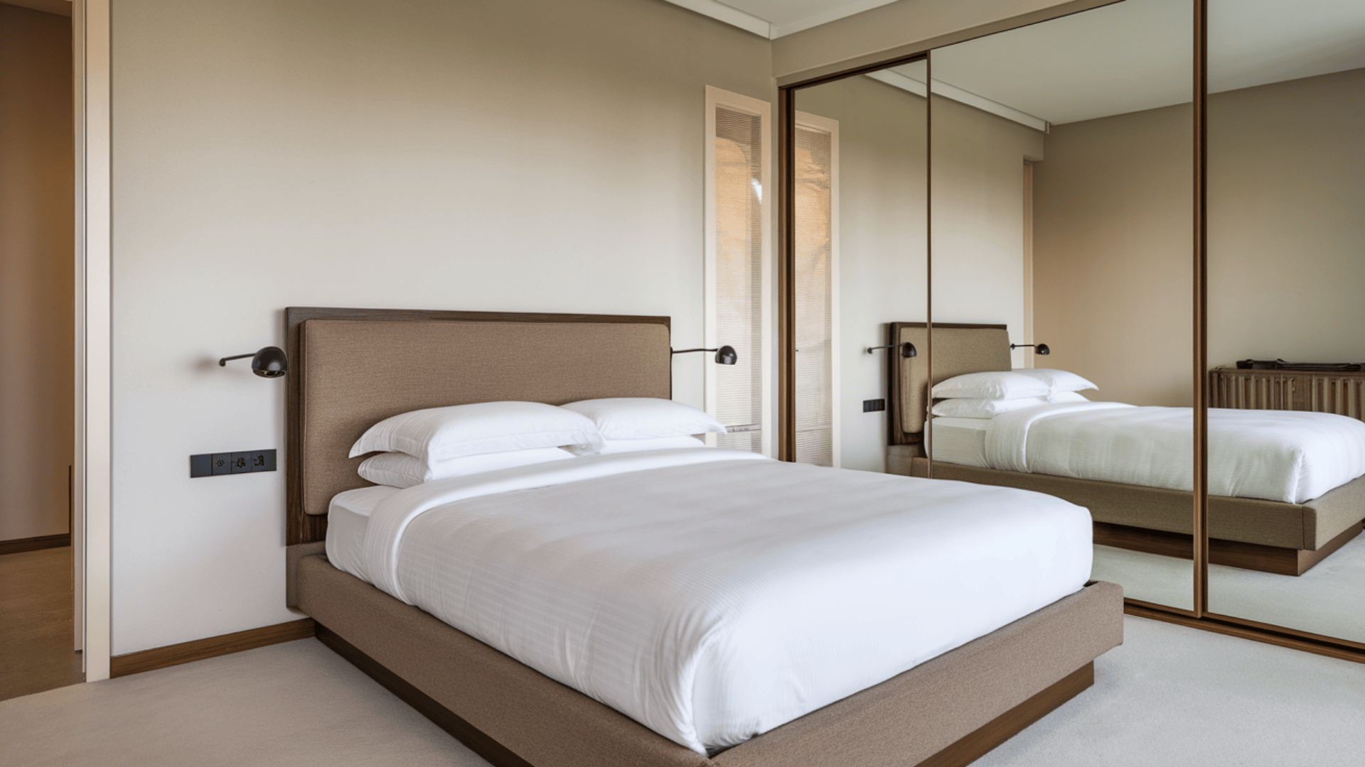 bedroom with bed placed diagonal to the door, solid headboard against wall, clear sides, and minimal decor