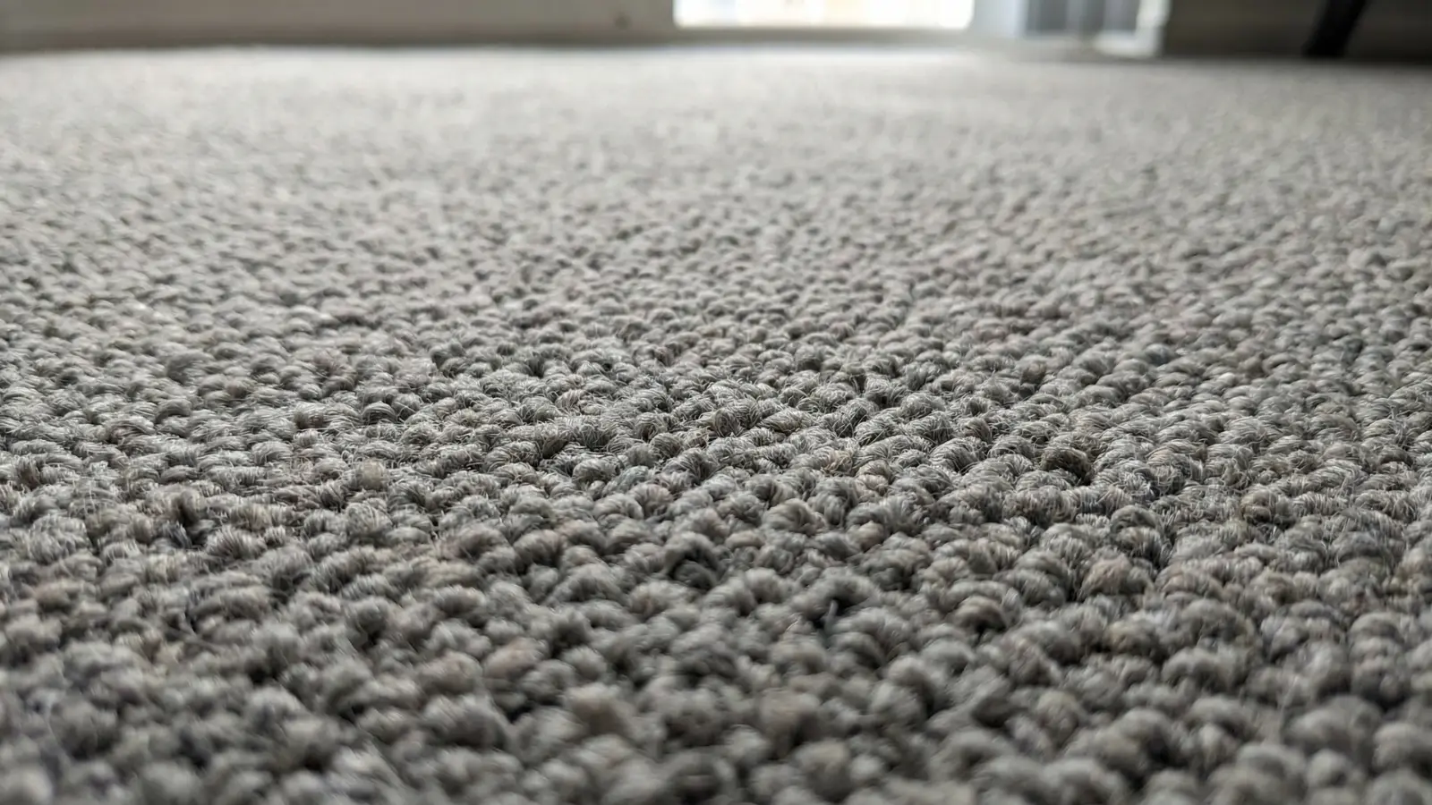 close-up of nylon carpet fibers with dense and durable texture in neutral tone
