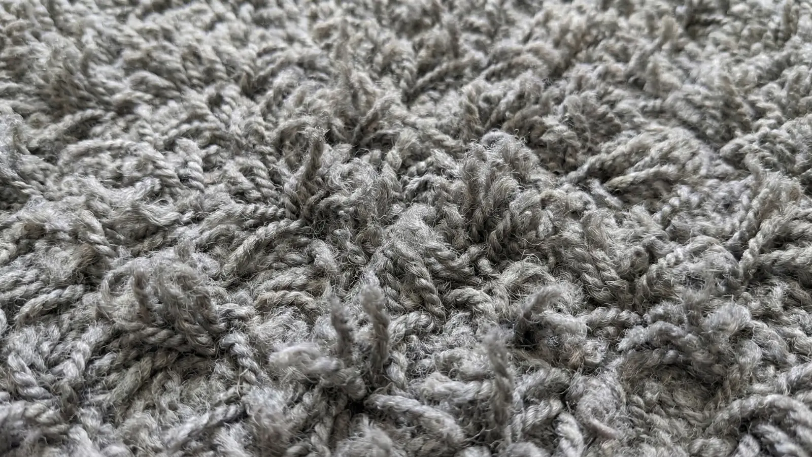 close-up of twisted frieze carpet fibers in grey