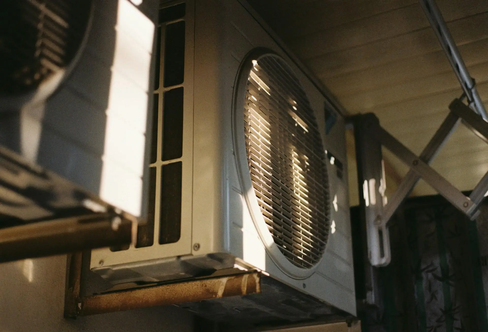 Outdoor air conditioning unit with metal casing mounted under a covered structure