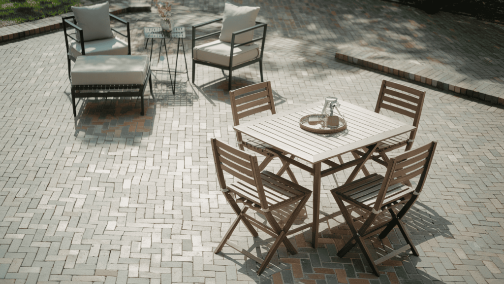 herringbone brick patio pattern in a backyard with separate dining and lounge zones