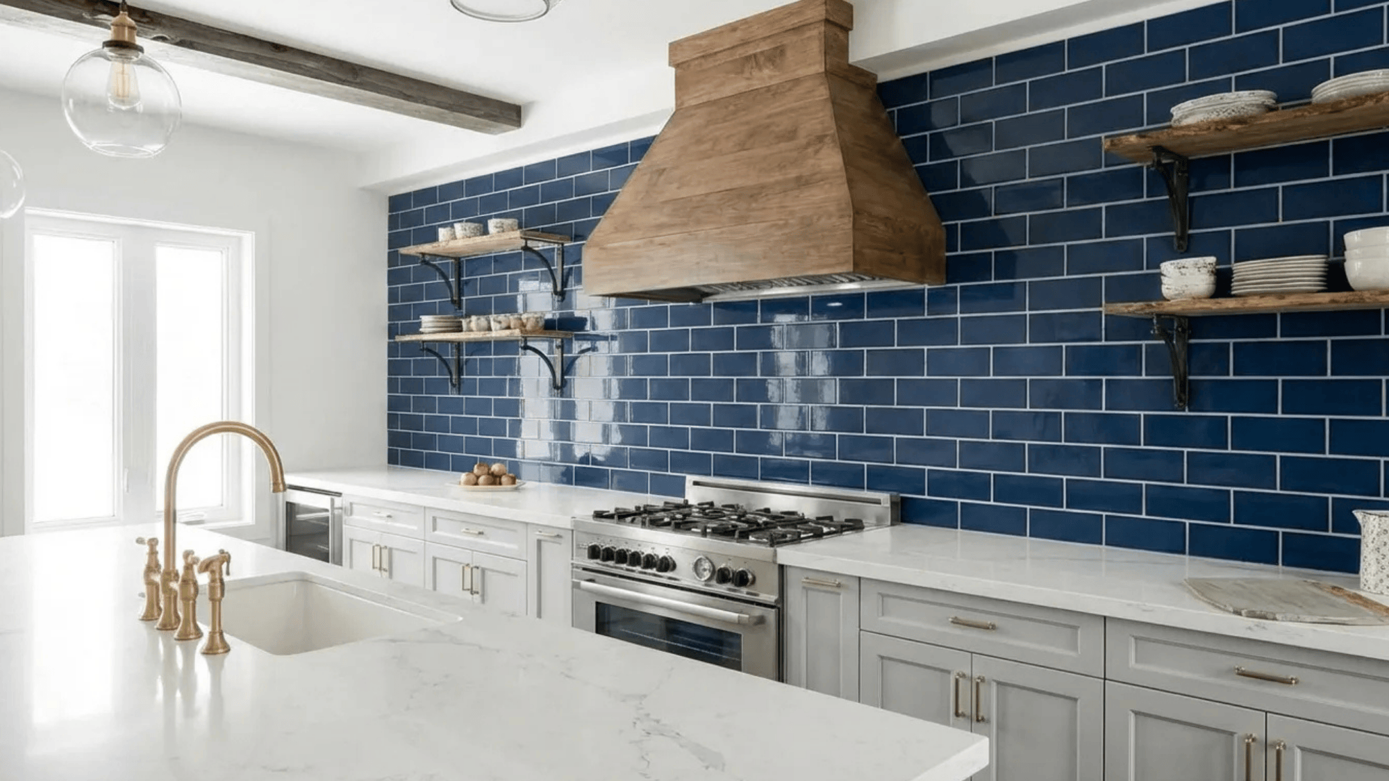 kitchen with navy blue subway tiles, white cabinetry, and a wooden range hood