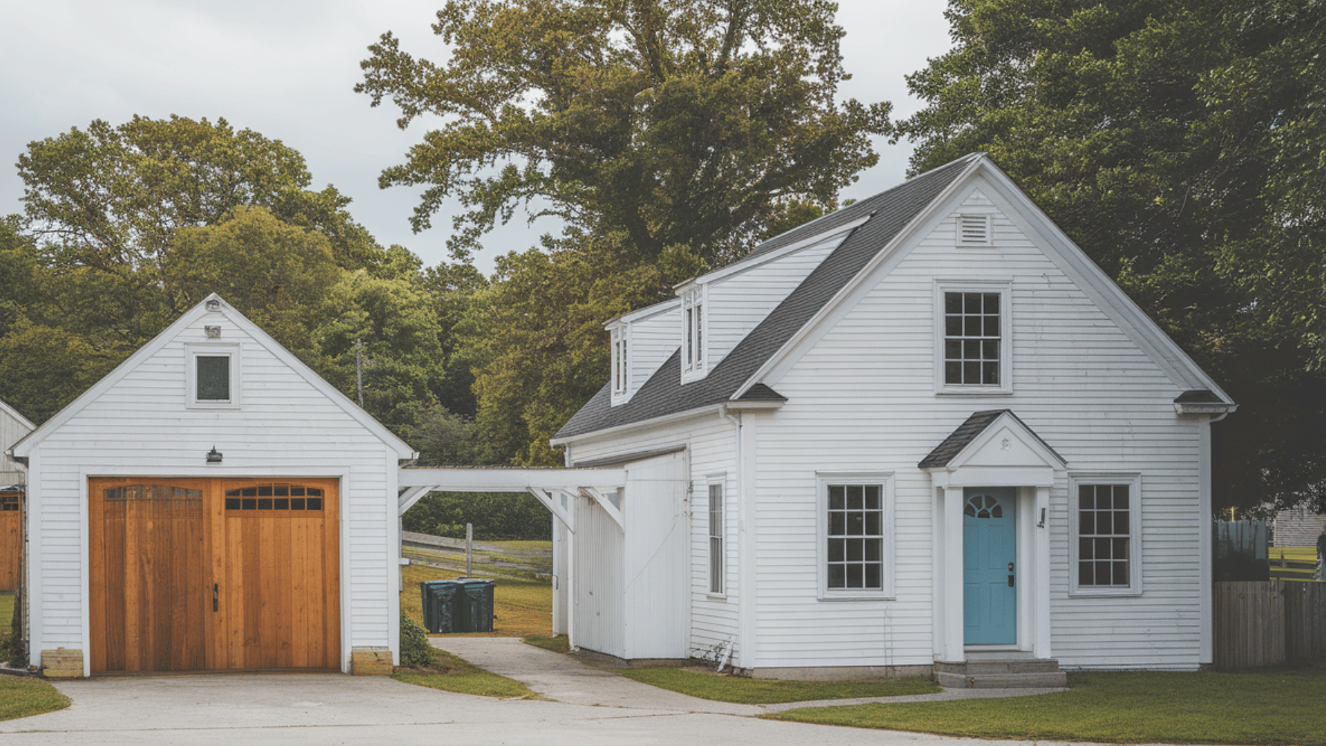 modern split-level garage on a sloped wooded lot with stone and wood finishes and a green living roof.