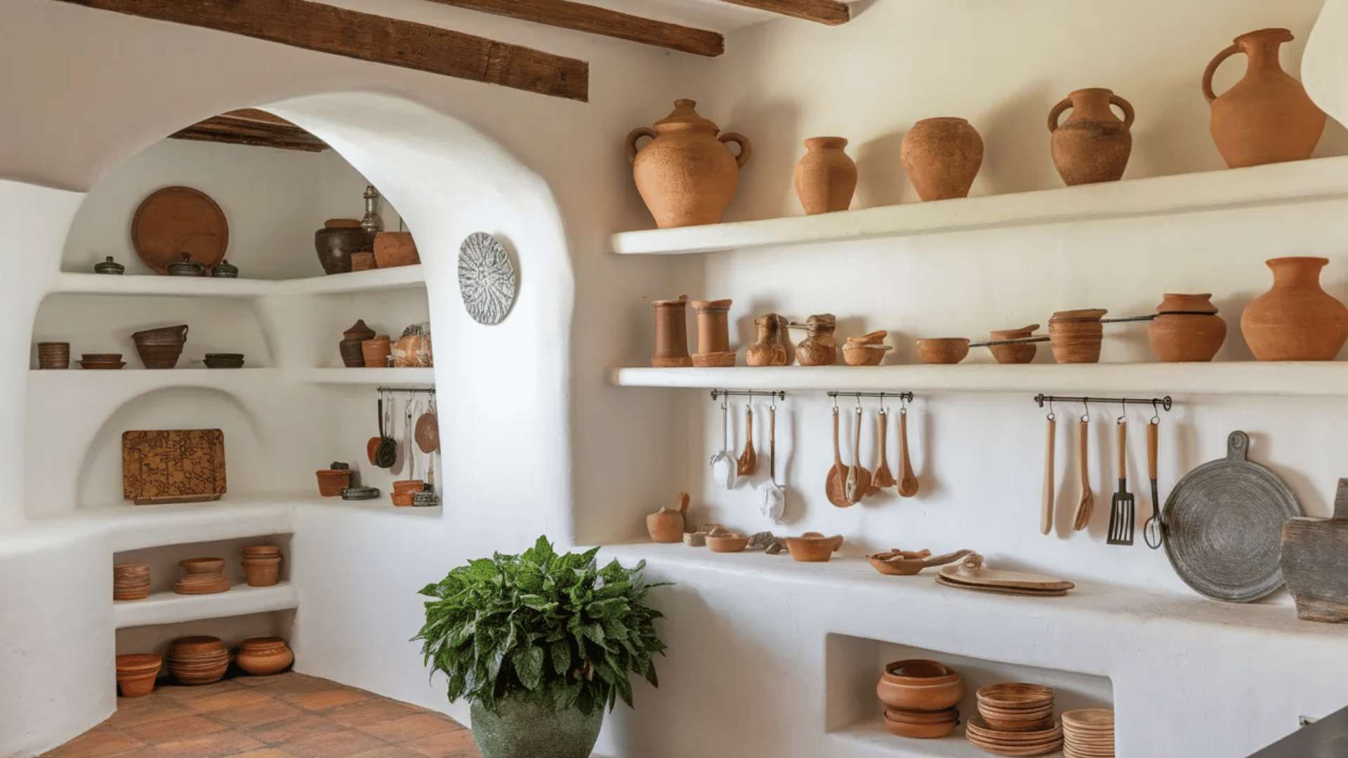 open shelving in kitchen displaying terracotta pottery and ceramics