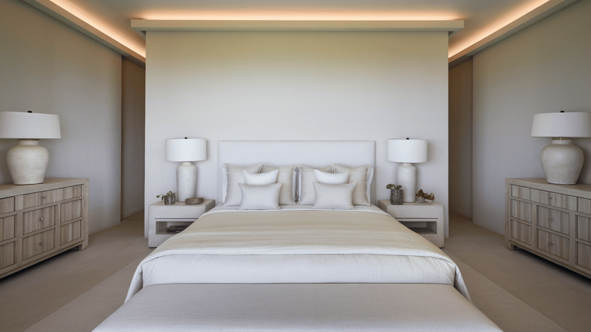 serene bedroom with centered bed, symmetrical nightstands and lamps, and layered neutral bedding textures