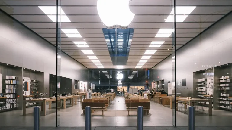 Modern tech store interior with displays and wooden tables under bright fluorescent lighting