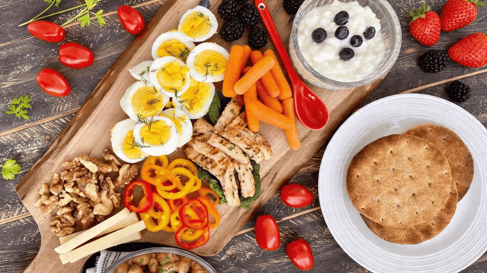 A board with fresh fruits, vegetables, and light proteins arranged neatly for a simple and healthy setup.