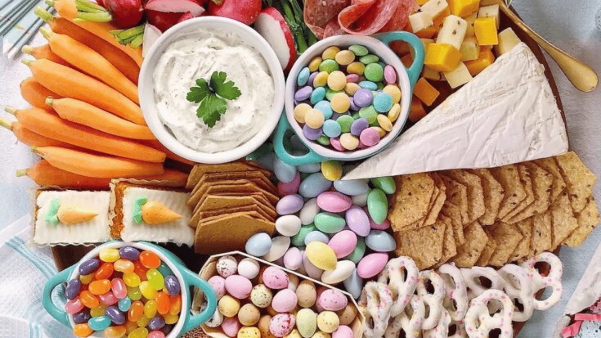 A colorful board with bite-sized snacks, fruits, and treats, arranged in simple patterns for kids to enjoy.