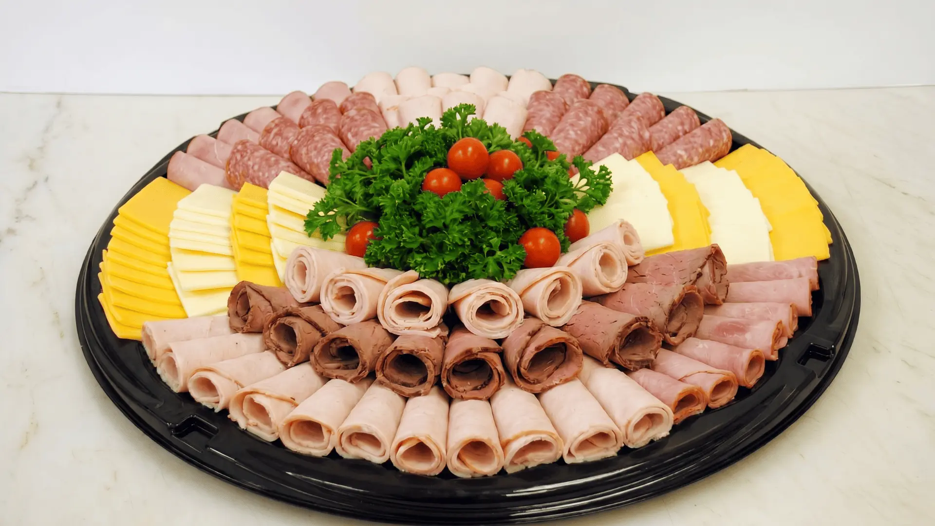 A deli board with sliced meats, bread, pickles, and condiments like mustard, arranged in layers for a simple savory spread.
