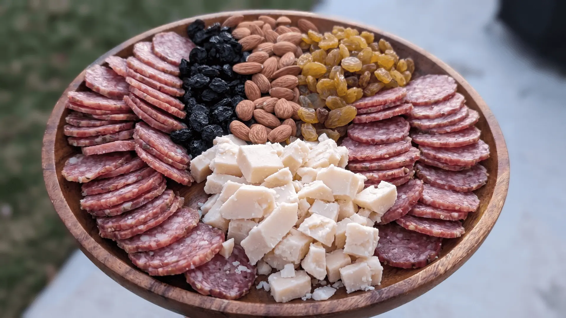 A filling board with eggs, meats, cheese, nuts, and fresh sides arranged in sections for a high-protein meal.