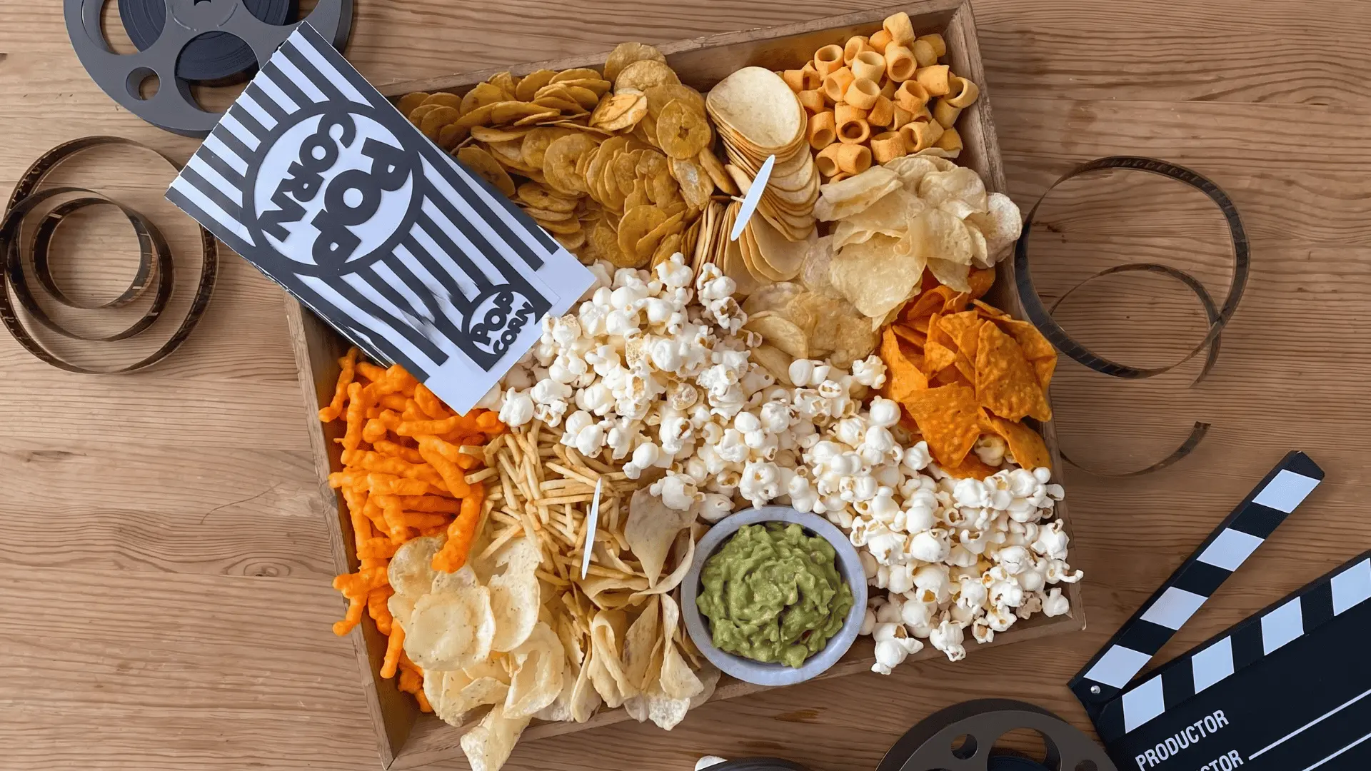 A snack board with chips, nuts, crackers, and dips arranged casually with a focus on crisp textures.