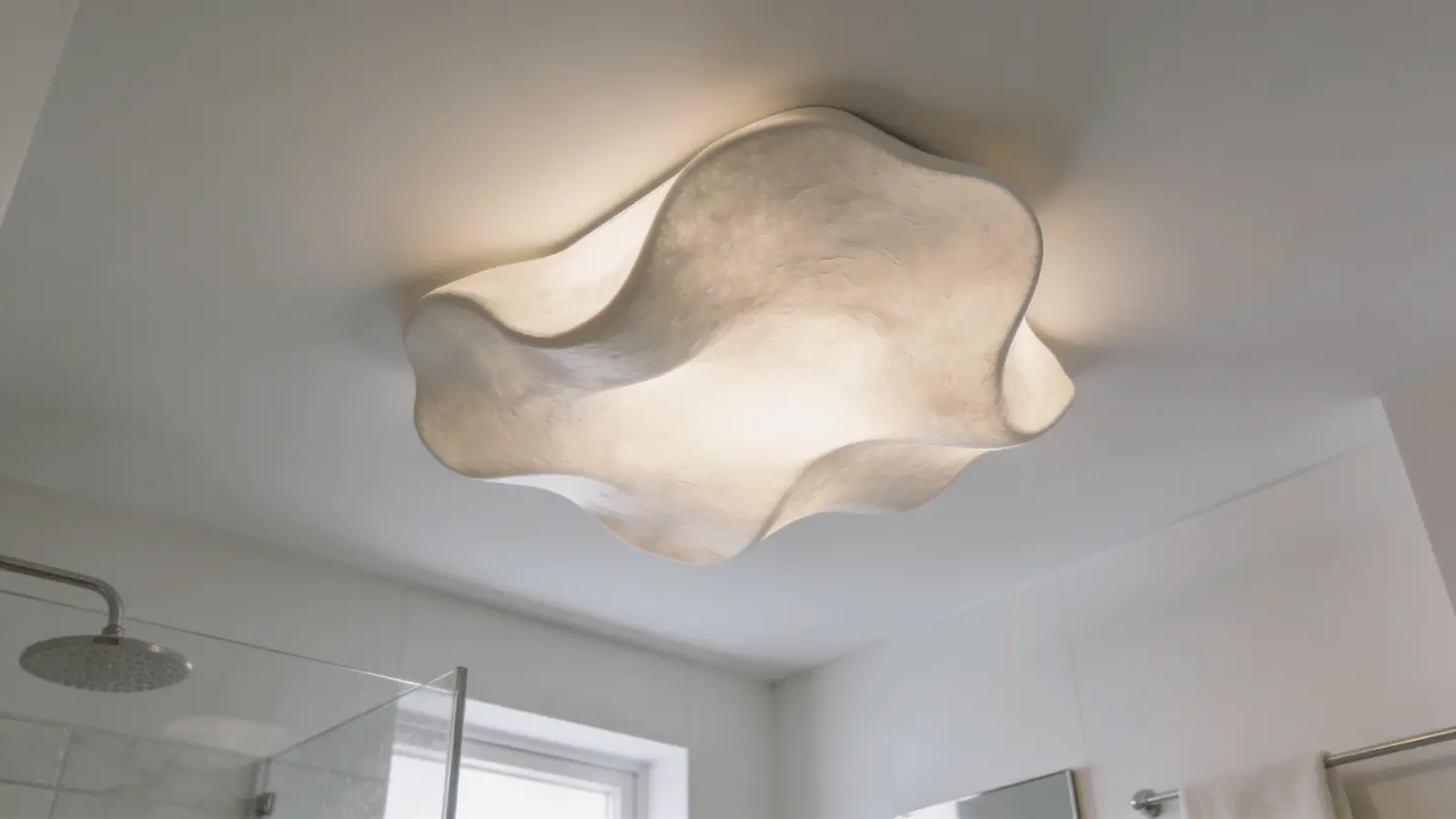 Abstract sculptural ceiling light fixture in a modern white bathroom.