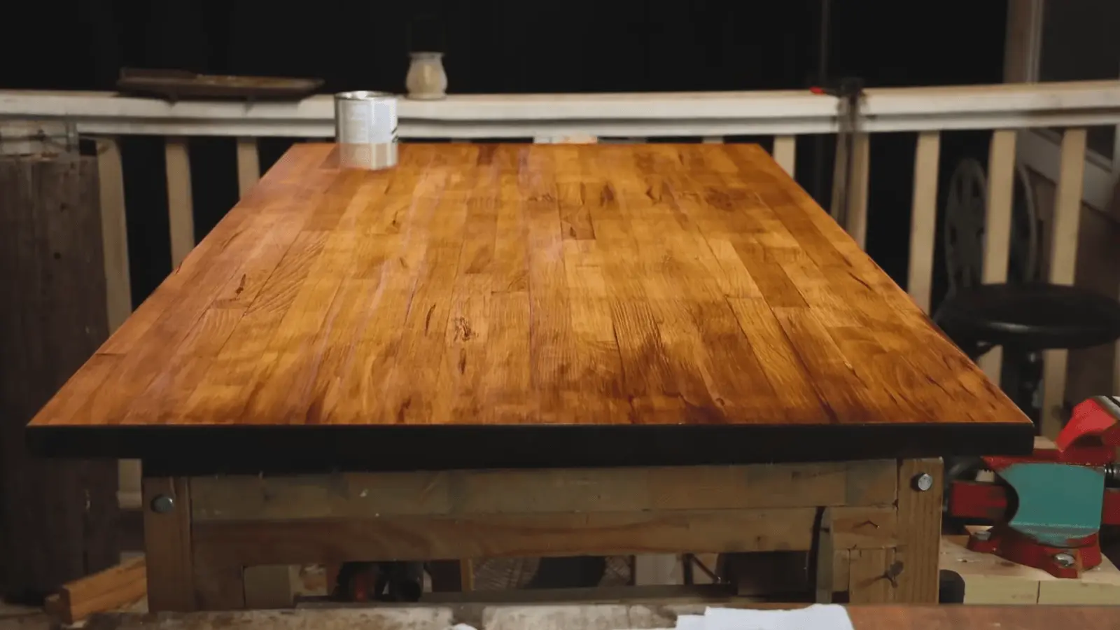 Applying wood stain and protective finish on wooden table surface indoors