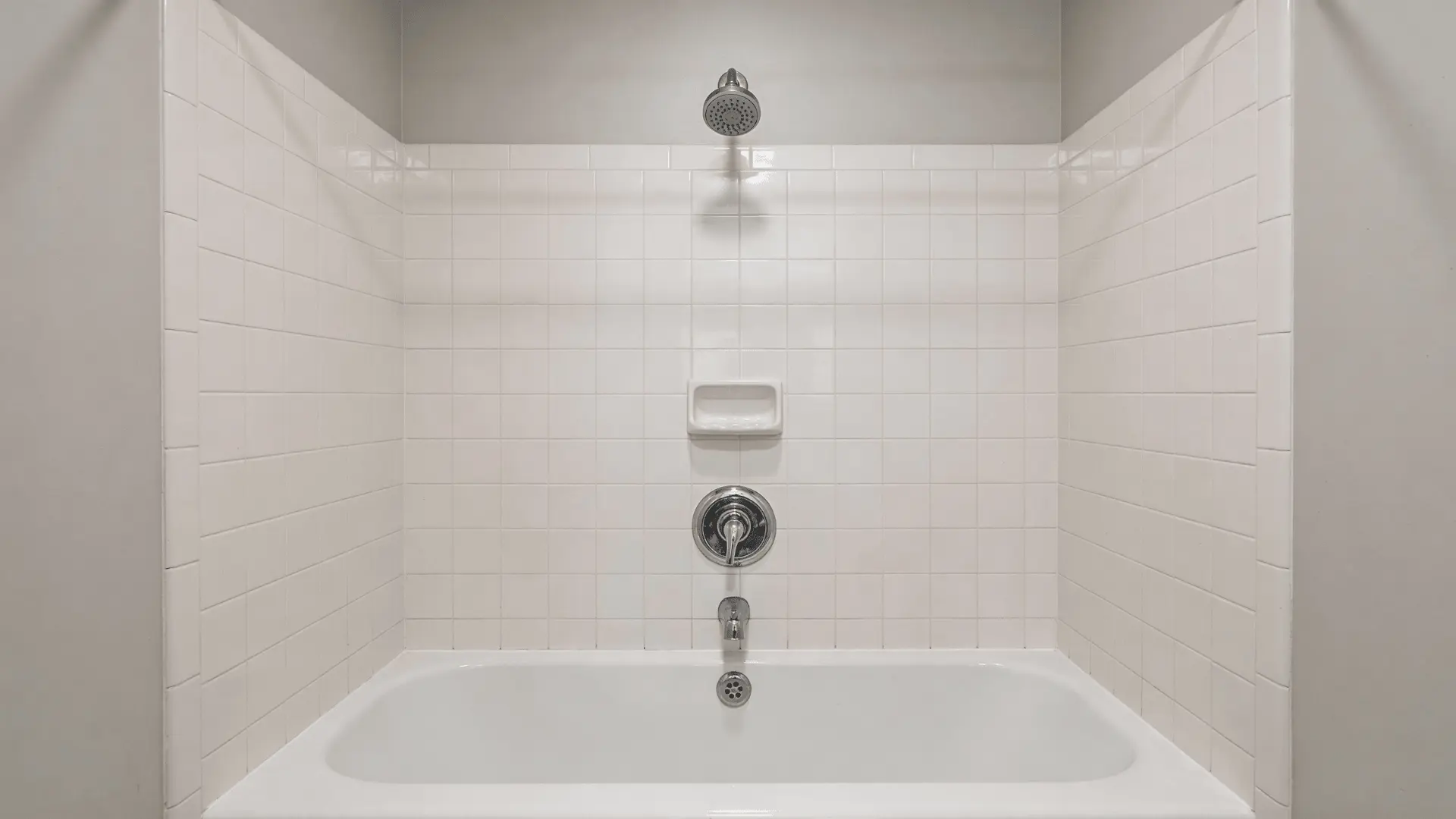 Bathtub wall setup showing spout below control valve and showerhead with visible vertical spacing