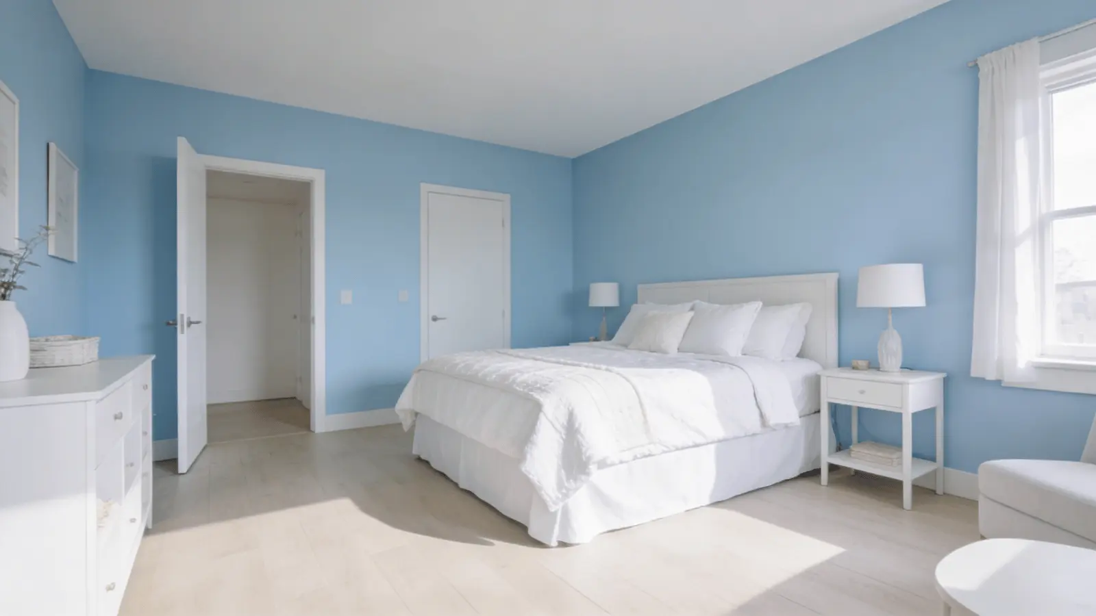 Bedroom with blue walls and white bedding and furniture