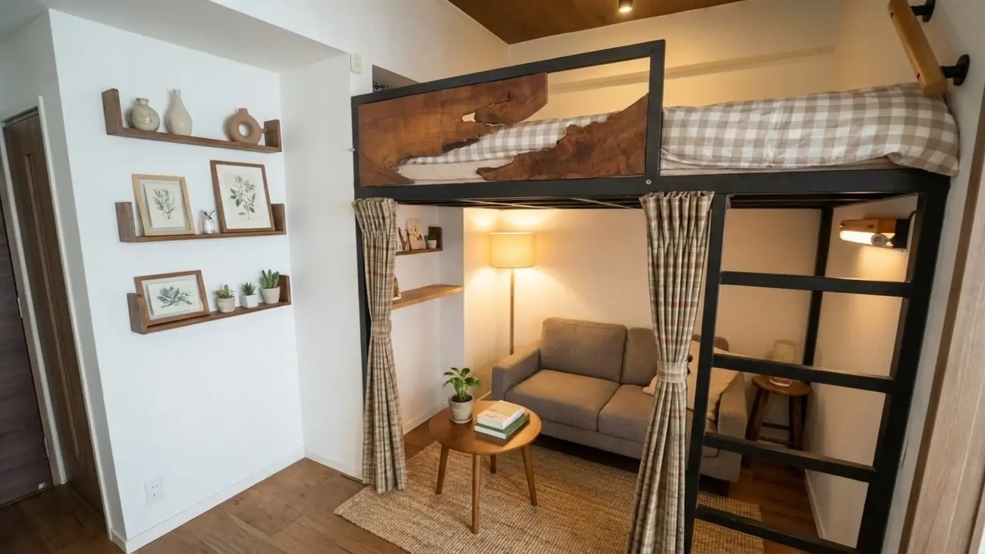 Loft bed with guardrails above a small living area featuring a sofa, round coffee table, ladder, curtains, and wall shelves.
