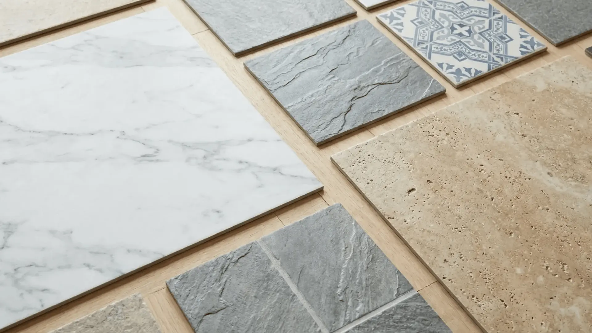 Luxury vinyl tiles displaying marble, slate, travertine, and ceramic tile style surface patterns arranged on a floor