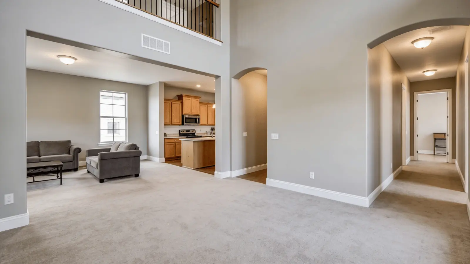 Open interior with Mega Greige walls across living area, kitchen, and hallway in natural light