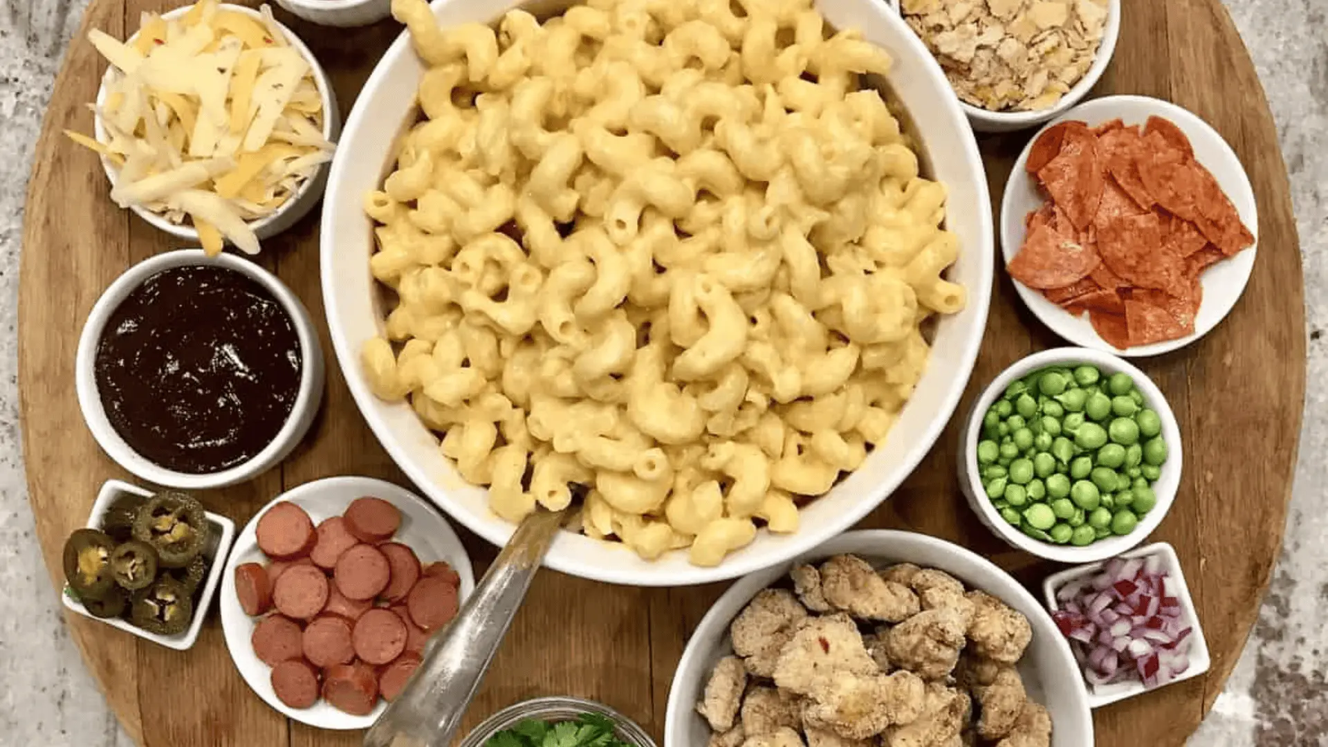 Pasta charcuterie board with different pasta, sauces, cheese, and toppings in separate sections