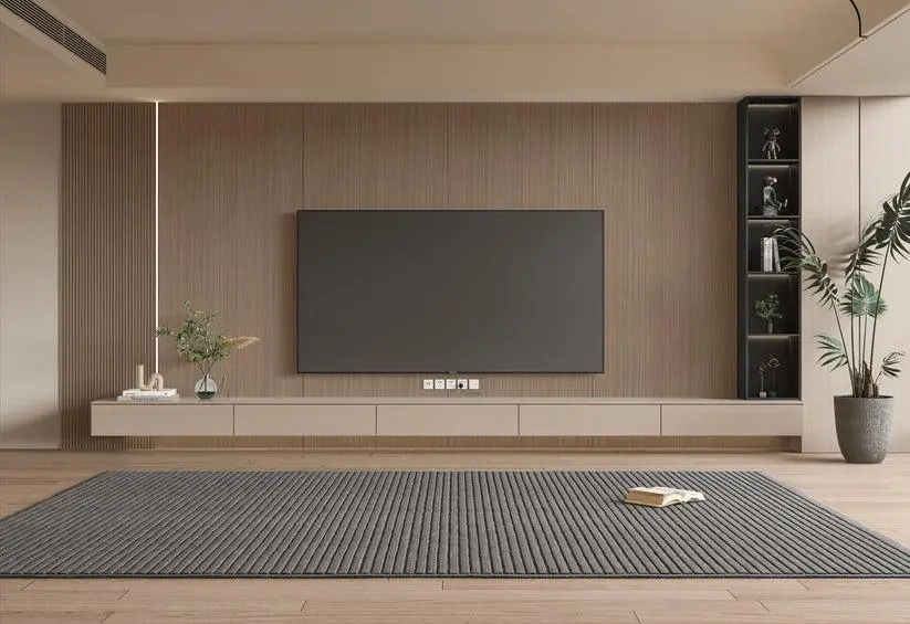 Minimalist living room with wall-mounted TV, beige accent wall, and gray rug on wooden floor