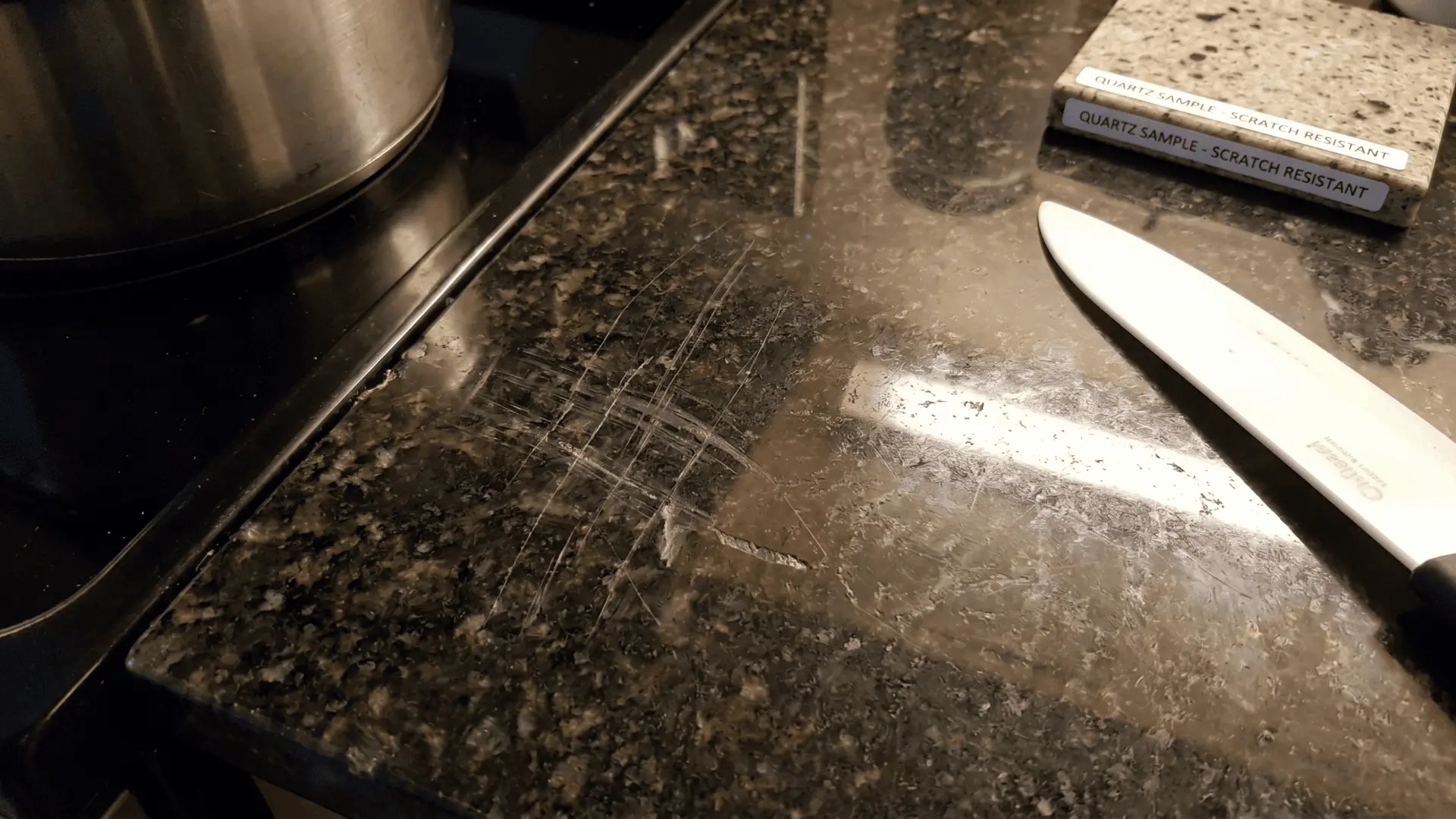 Scratched kitchen countertop surface with visible knife marks and wear from regular cutting use