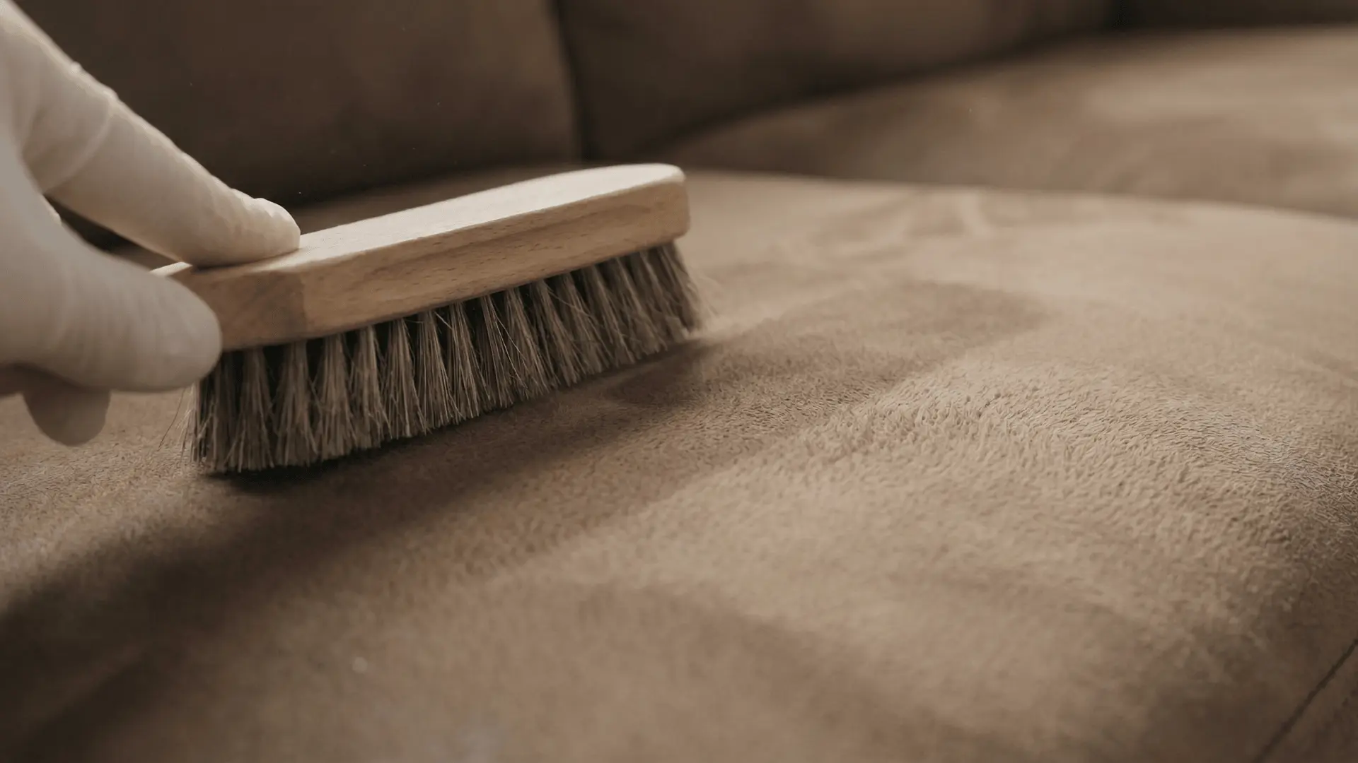 Suede brush lifting fibers on couch fabric surface showing texture change