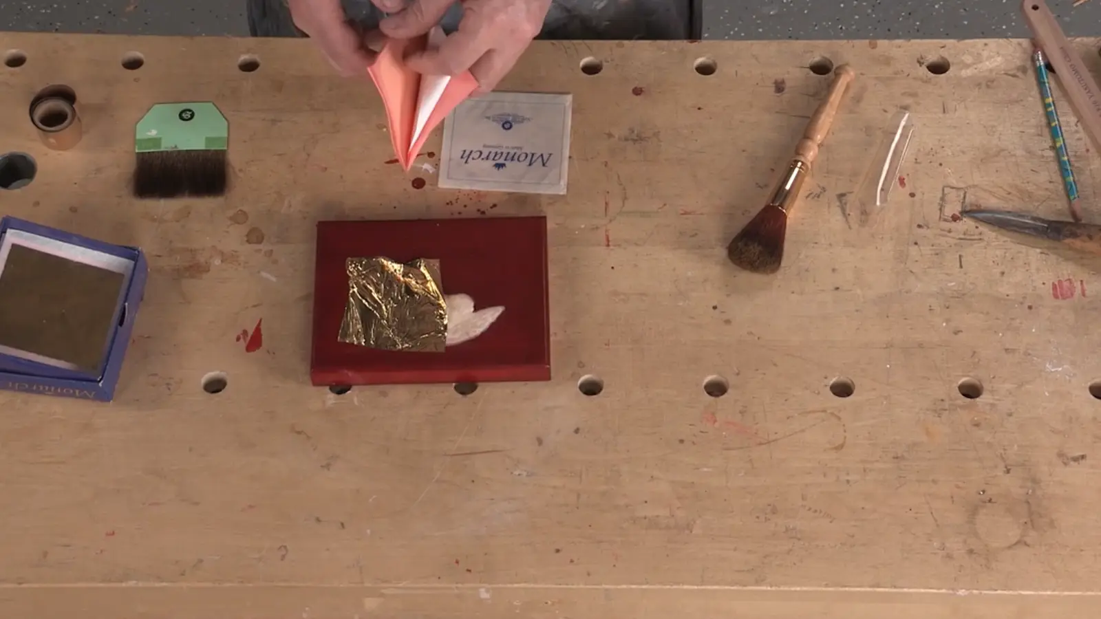 Thin sheets of 23-karat gold leaf gently placed over a tacky adhesive surface”