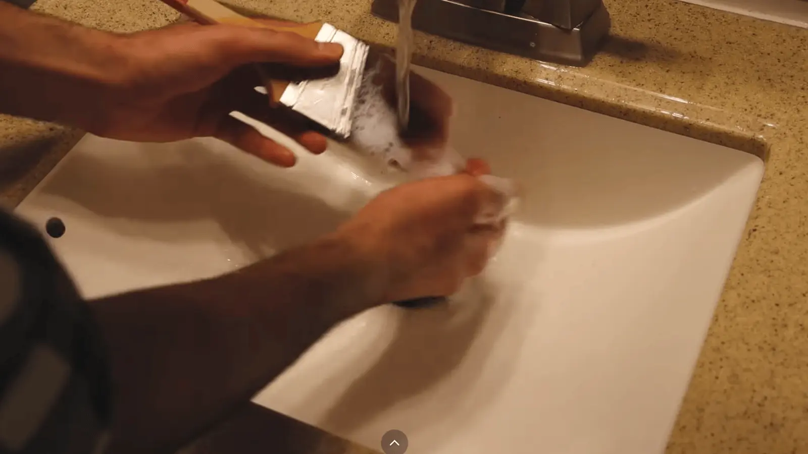 Washing paintbrush with soap and water after use