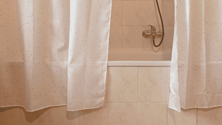 _A bathtub with a white shower curtain