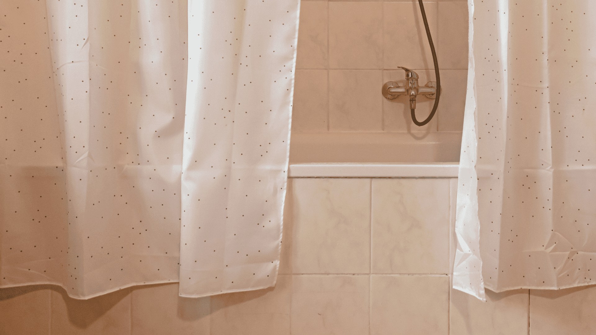 _A bathtub with a white shower curtain